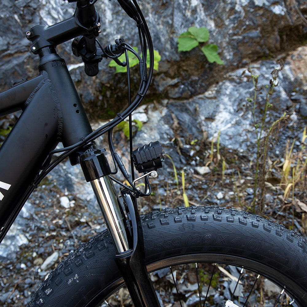 Close-up of the front fork and thick tire on the I Got It First 1000W electric fat tire bike in black