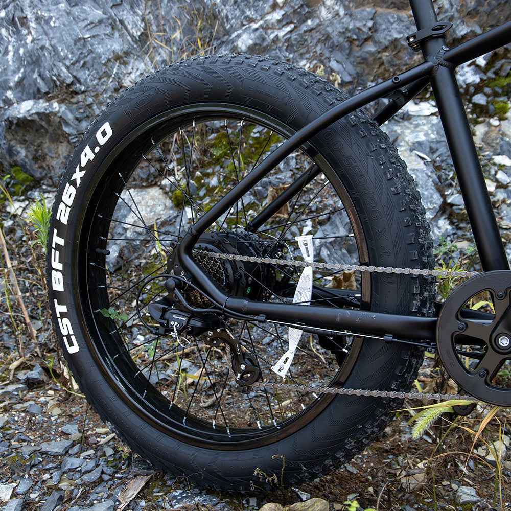 Rear wheel and fat tire of I Got It First 1000W electric fat tire bike on rocky terrain